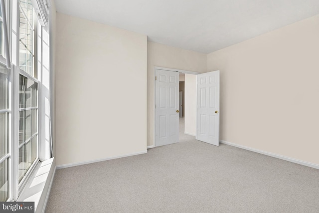 empty room with carpet and baseboards