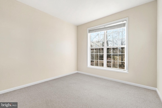 empty room featuring light carpet and baseboards