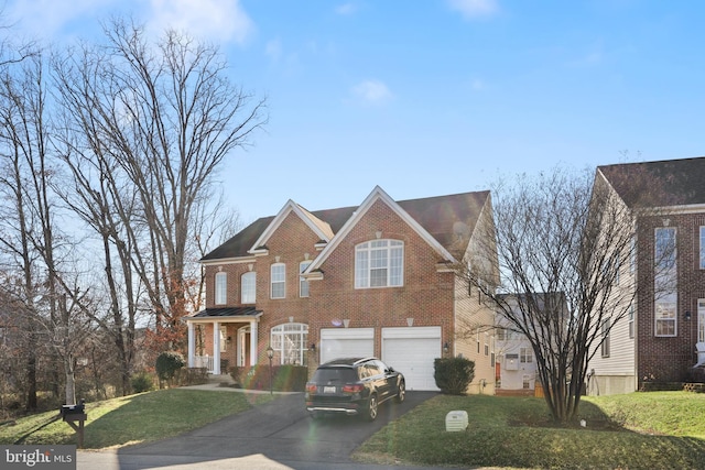 view of front of home featuring a garage, driveway, brick siding, and a front lawn