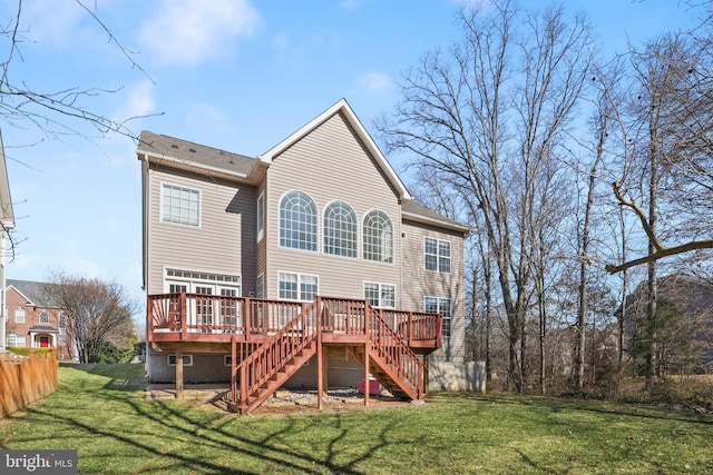 rear view of house featuring stairway, a lawn, and a wooden deck