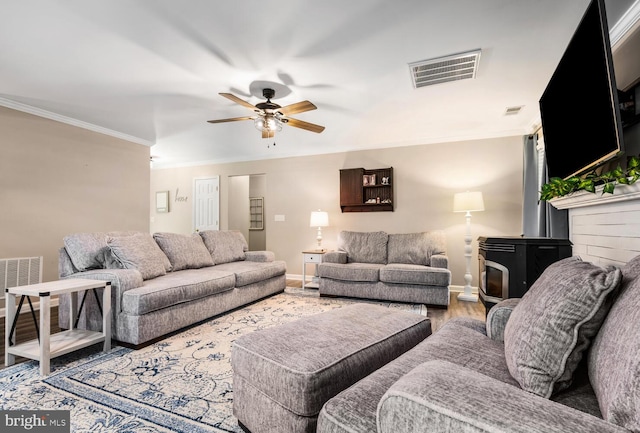 15185 Day Rd, Goldsboro, MD 21636 - living room with baseboards, ornamental molding, ceiling fan, wood finished floors, and a wood stove