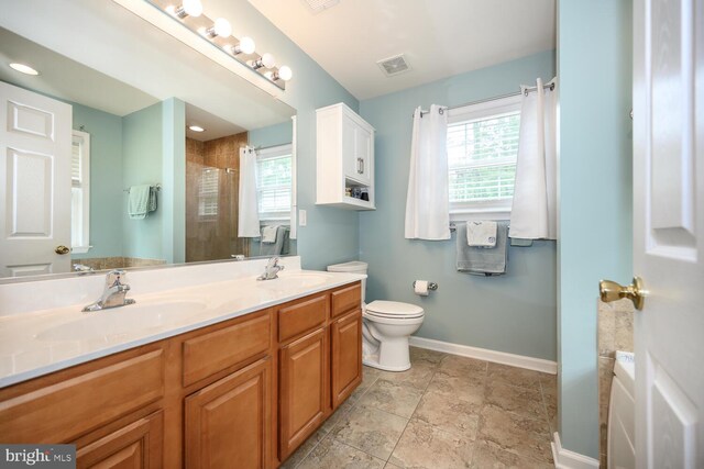 15185 Day Rd, Goldsboro, MD 21636 - bathroom with baseboards, tiled shower, double vanity, and toilet