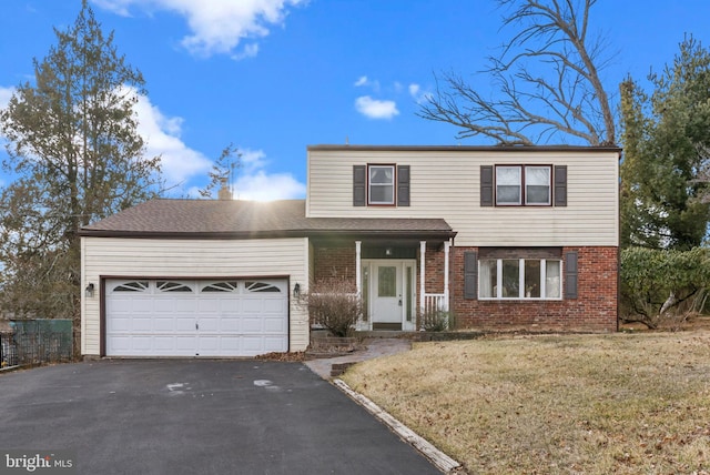 traditional home with a front lawn, brick siding, driveway, and an attached garage