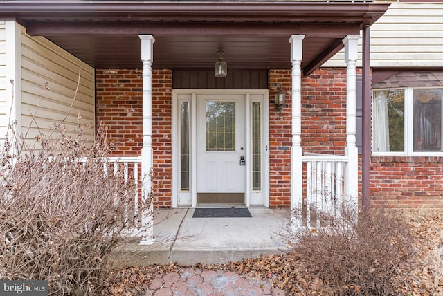 doorway to property featuring brick siding