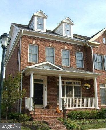 view of front of home featuring brick siding and covered porch