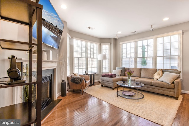 living room with visible vents, recessed lighting, a fireplace, and hardwood / wood-style floors