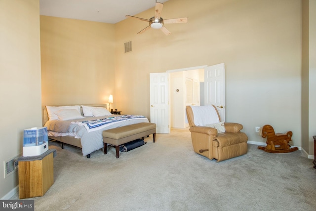 bedroom with visible vents, baseboards, a high ceiling, and carpet