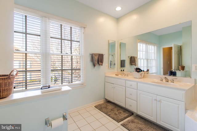 full bath featuring tile patterned flooring, plenty of natural light, and a sink