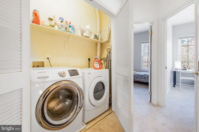 washroom with laundry area, washing machine and dryer, and light carpet