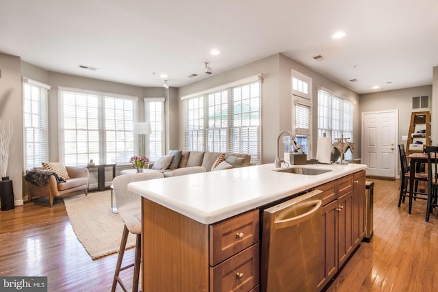 kitchen with visible vents, a sink, light wood-type flooring, and stainless steel dishwasher