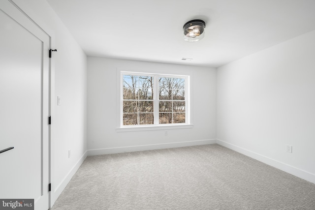 unfurnished room featuring carpet, visible vents, and baseboards