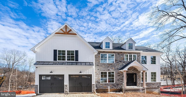 view of front facade with a garage, a standing seam roof, metal roof, and driveway