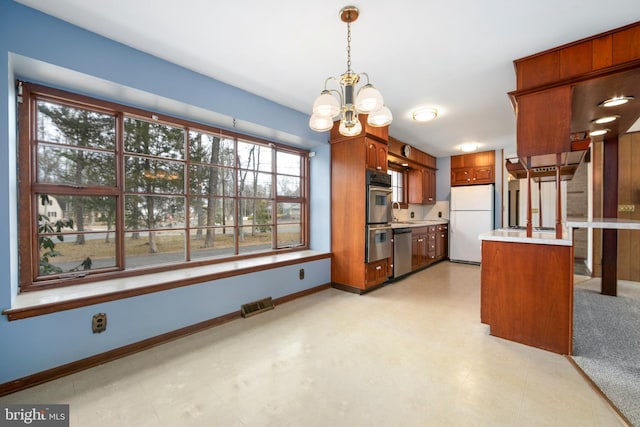 kitchen featuring visible vents, appliances with stainless steel finishes, an inviting chandelier, light countertops, and light floors