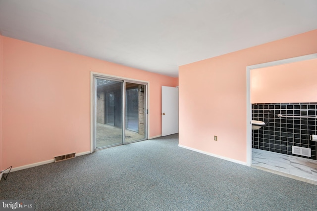 empty room featuring carpet flooring, visible vents, and baseboards