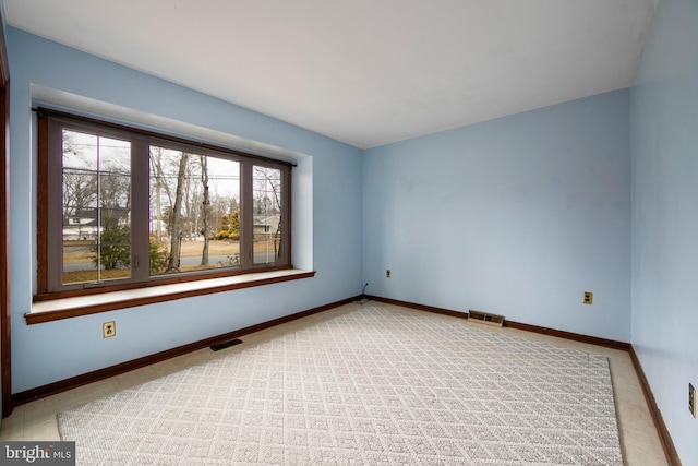 unfurnished room featuring baseboards and visible vents