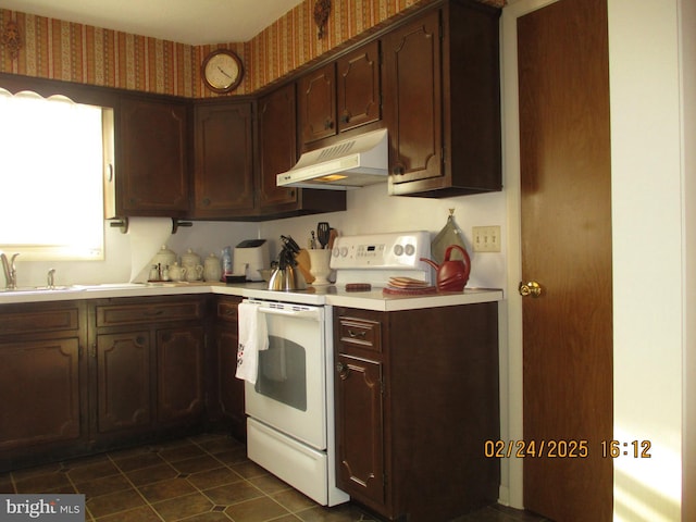 kitchen with light countertops, white electric range, a sink, under cabinet range hood, and wallpapered walls