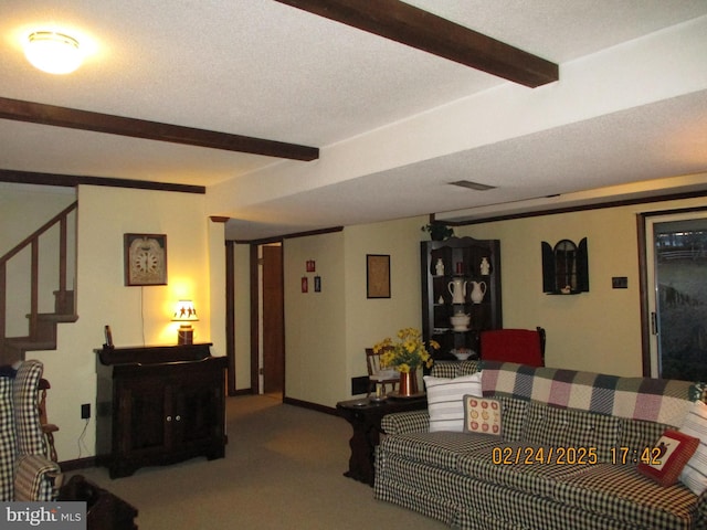 carpeted living area featuring beam ceiling, visible vents, baseboards, and stairs