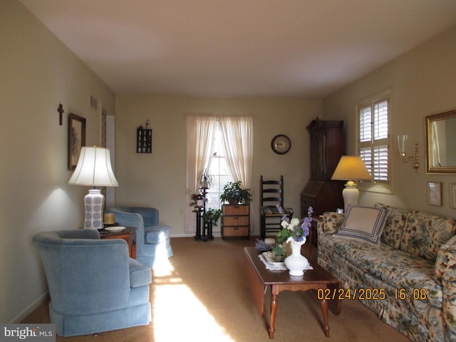 carpeted living room with baseboards and visible vents