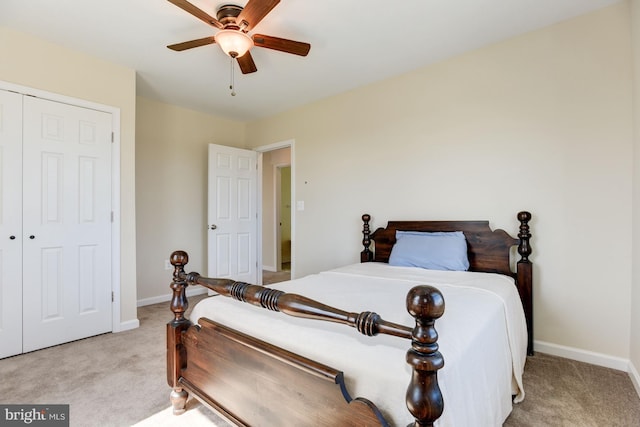 bedroom featuring light carpet, a closet, a ceiling fan, and baseboards