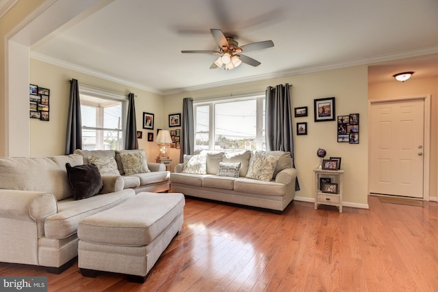 living room with light wood-type flooring, plenty of natural light, and ornamental molding