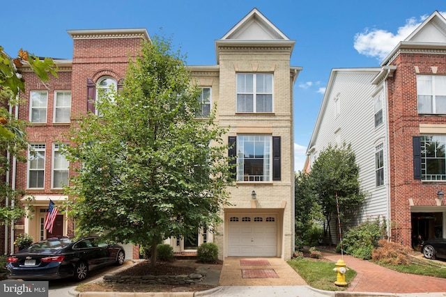 townhome / multi-family property with brick siding and an attached garage