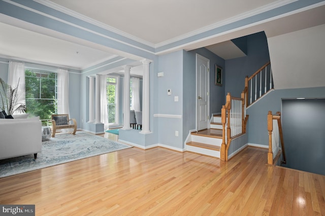 entrance foyer featuring baseboards, stairway, ornate columns, and wood finished floors