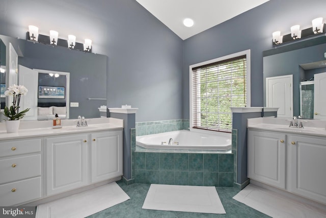 bathroom featuring two vanities, a sink, a bath, and tile patterned floors