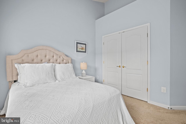 bedroom with a closet, carpet flooring, and baseboards