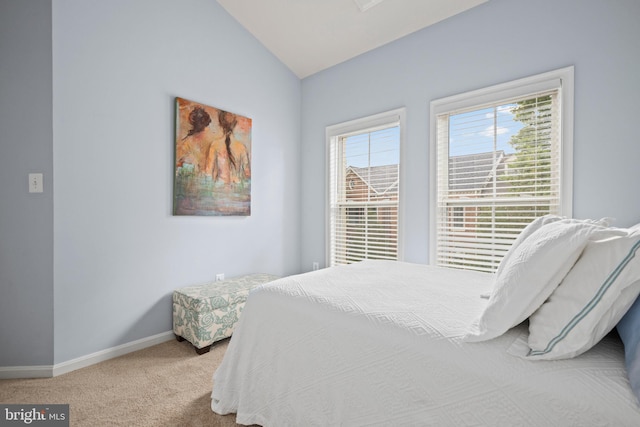 bedroom with carpet floors, vaulted ceiling, and baseboards