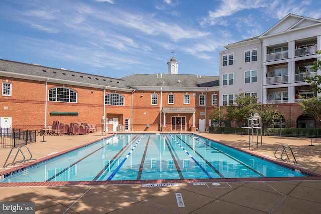 pool with fence and a patio