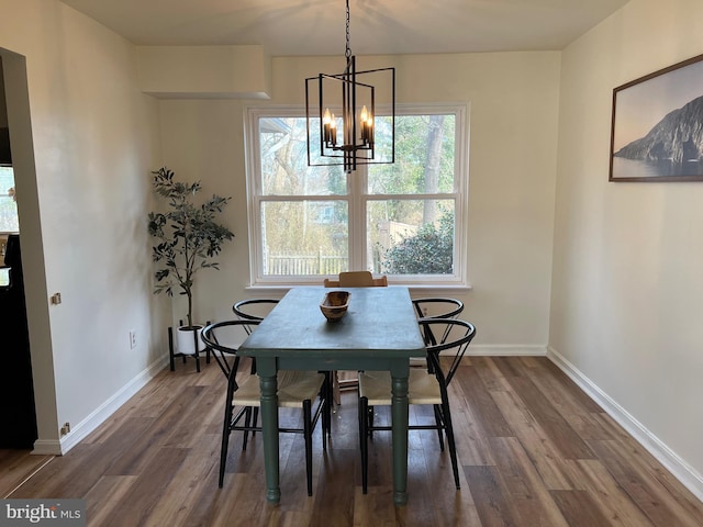 dining area with baseboards, a chandelier, and dark wood finished floors