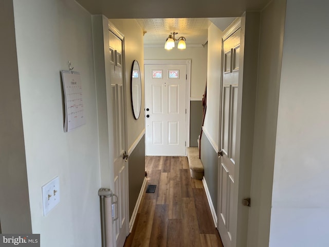 entryway with dark wood-style floors, visible vents, and a chandelier