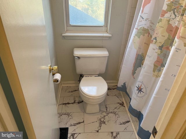 full bathroom featuring marble finish floor, a shower with curtain, toilet, and baseboards