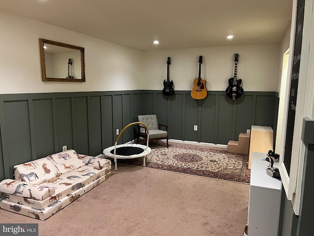 living area featuring a wainscoted wall, carpet, and recessed lighting