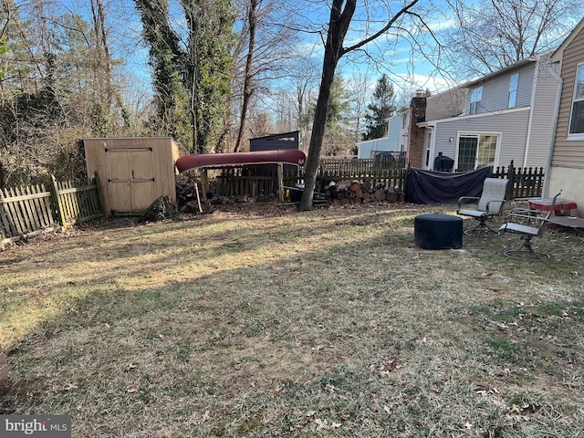 view of yard featuring a storage shed, fence, and an outbuilding