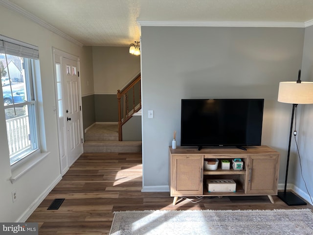 entryway with visible vents, stairway, ornamental molding, a healthy amount of sunlight, and wood finished floors