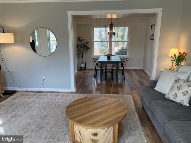 living room with a notable chandelier, baseboards, and wood finished floors