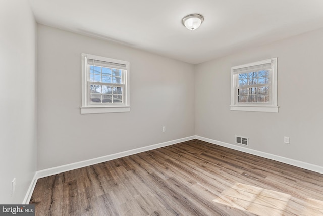 unfurnished room with plenty of natural light, visible vents, and baseboards