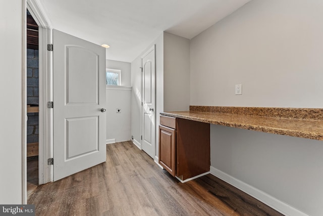 interior space featuring baseboards and wood finished floors