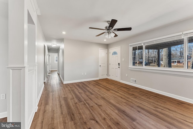 interior space with recessed lighting, wood finished floors, a ceiling fan, visible vents, and baseboards