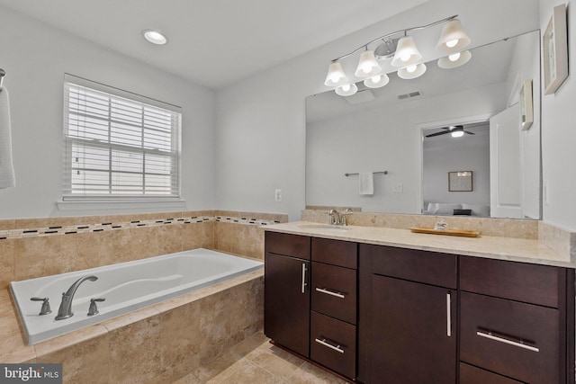 bathroom with a garden tub, visible vents, and vanity