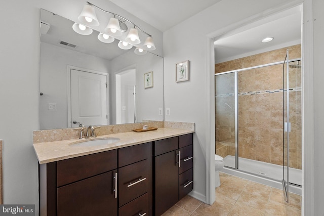 bathroom featuring a stall shower, tile patterned flooring, vanity, and toilet