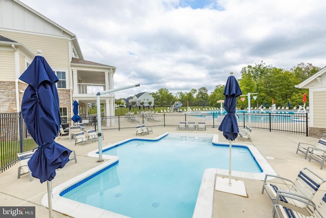 community pool featuring a patio area and fence