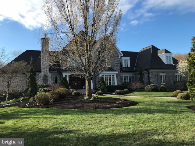 view of front of property featuring stone siding and a front lawn