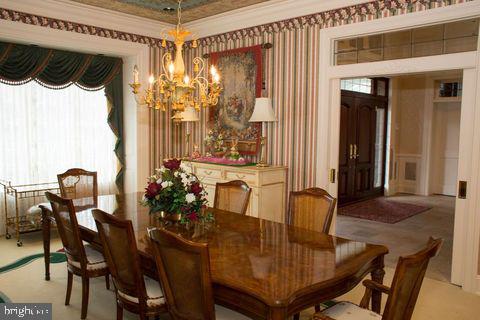 dining room featuring wallpapered walls, plenty of natural light, a chandelier, and crown molding