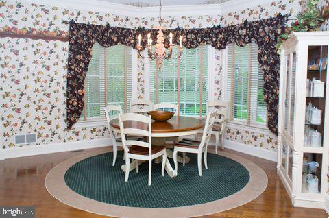 dining room featuring a notable chandelier, ornamental molding, baseboards, and wallpapered walls