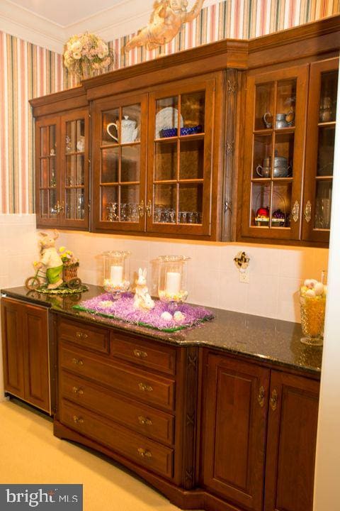 bar with ornamental molding and wallpapered walls