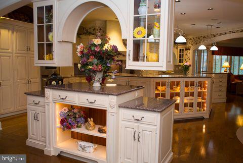 bar with dark wood-style floors and decorative light fixtures