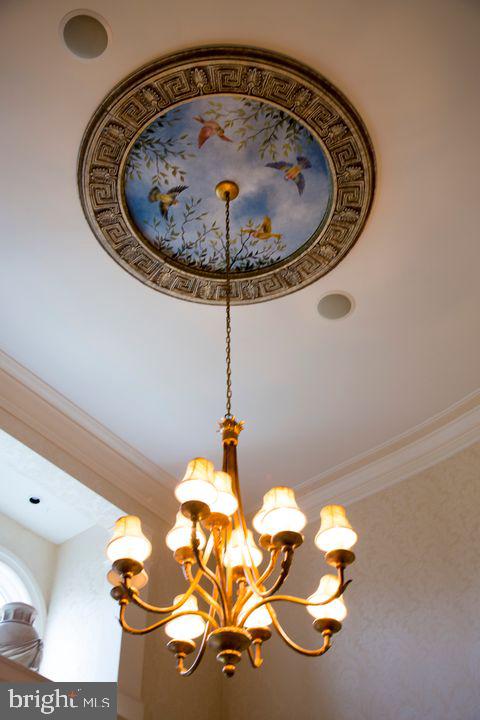 room details with ornamental molding and an inviting chandelier