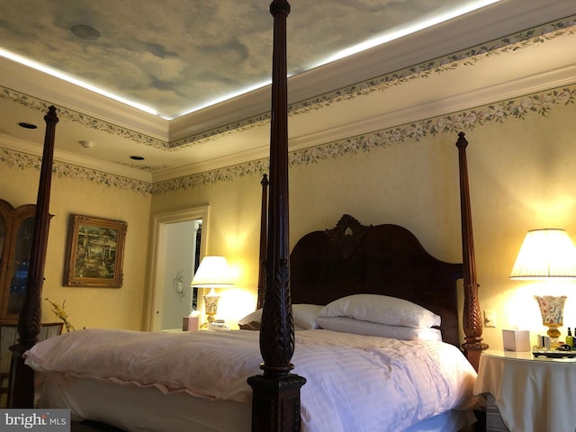 bedroom with ornamental molding and a raised ceiling